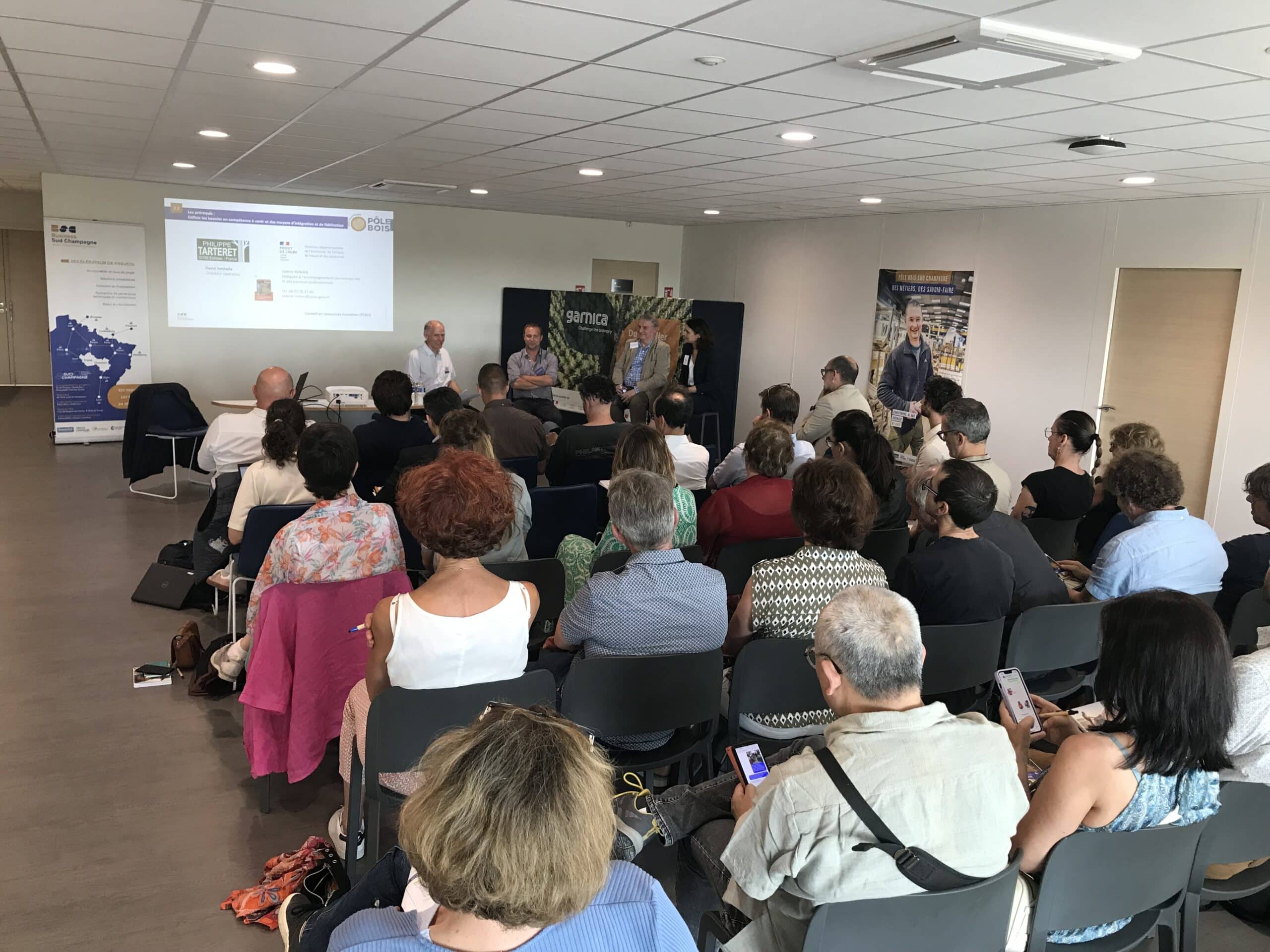 Conférence avec public attentif dans une salle.