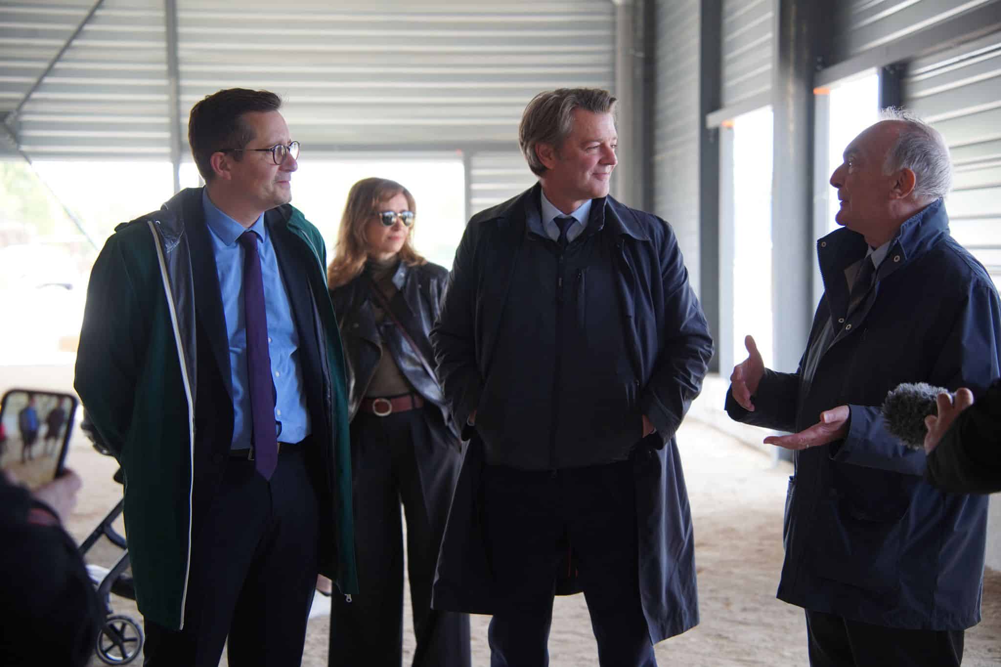Quatre personnes discutant dans un bâtiment industriel.