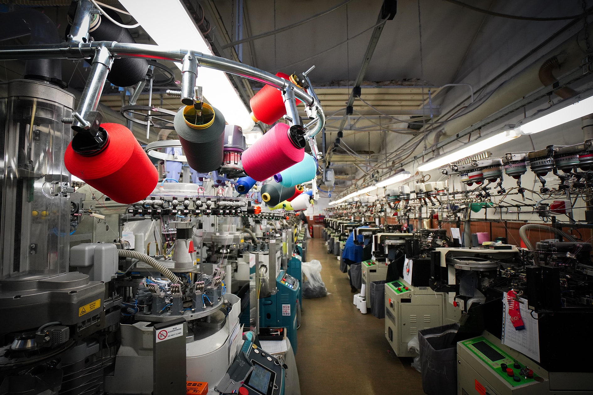 Atelier textile avec machines et bobines colorées.