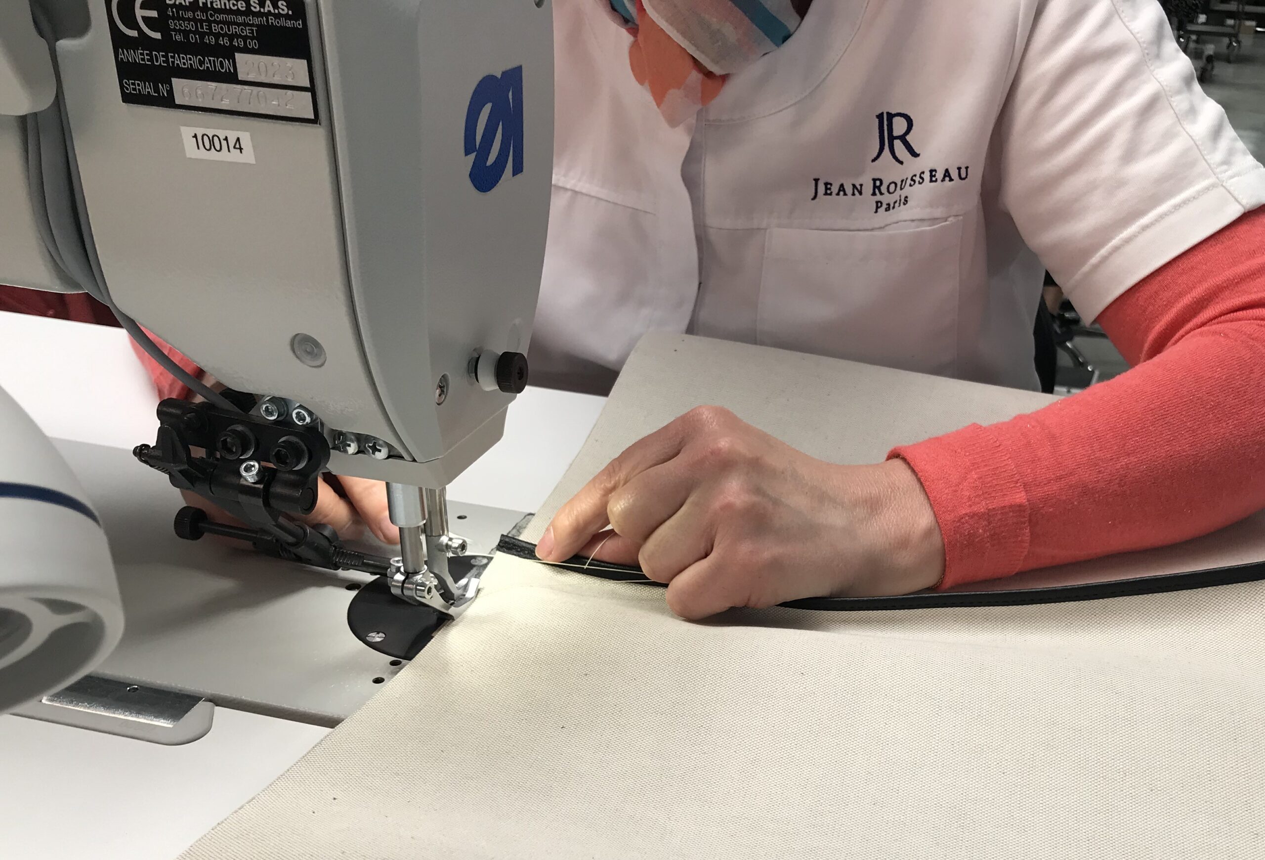 Personne utilisant une machine à coudre industrielle.