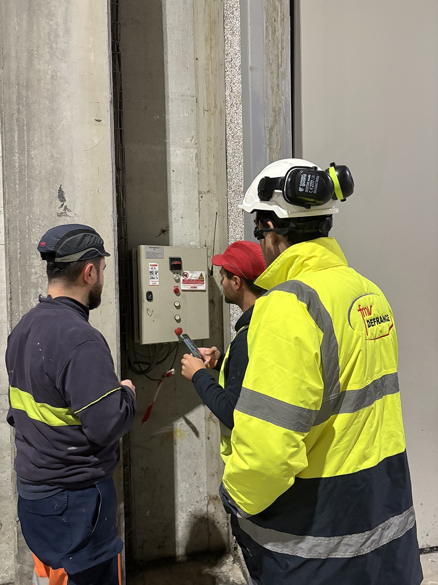Techniciens vérifiant un panneau électrique